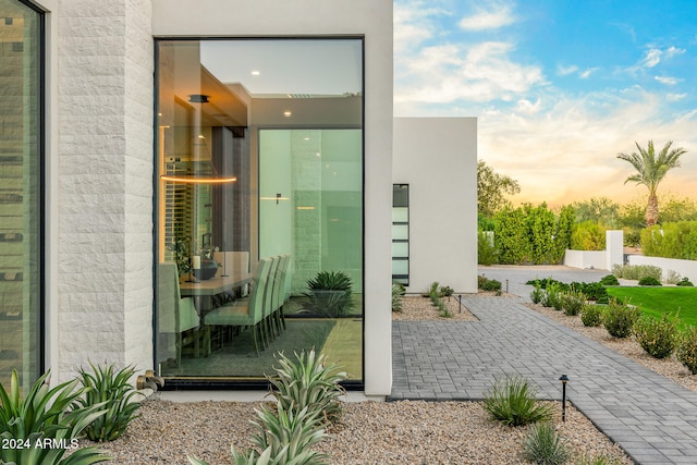 exterior entry at dusk featuring a patio area