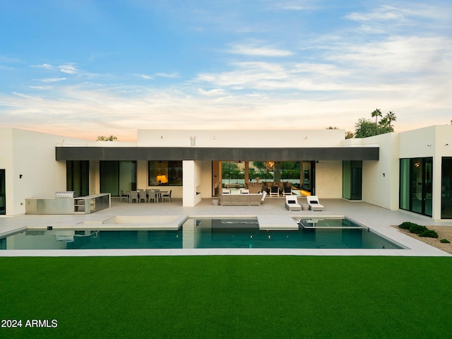 rear view of property with a lawn, area for grilling, a patio, and an outdoor living space