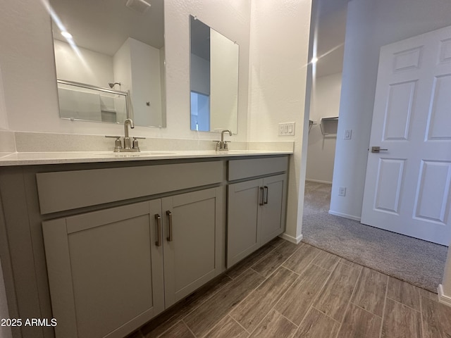 46922 W Coe St, Maricopa, AZ 85139 - full bathroom featuring wood tiled floors, a stall shower, double vanity, a spacious closet, and baseboards
