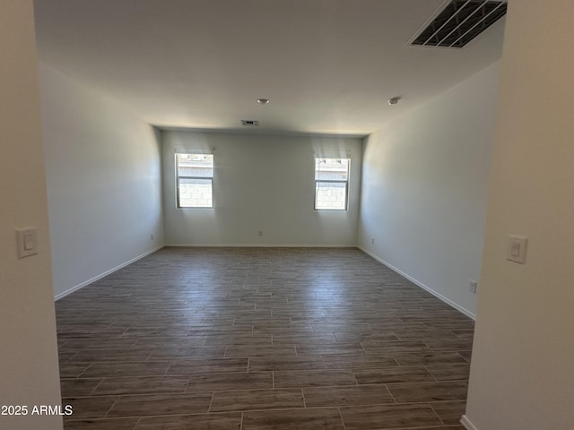 46922 W Coe St, Maricopa, AZ 85139 - spare room with healthy amount of natural light, dark wood-type flooring, and baseboards
