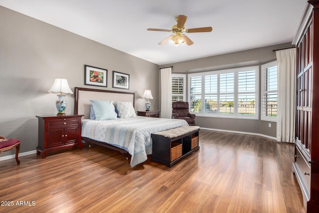 bedroom with a ceiling fan, baseboards, and wood finished floors