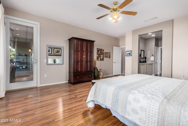 bedroom featuring wood finished floors, visible vents, and baseboards