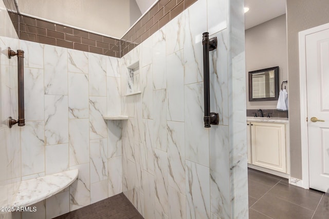 full bathroom with tile patterned flooring, a marble finish shower, and vanity