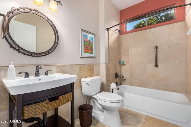 bathroom featuring wainscoting, toilet, shower / tub combination, vanity, and tile walls