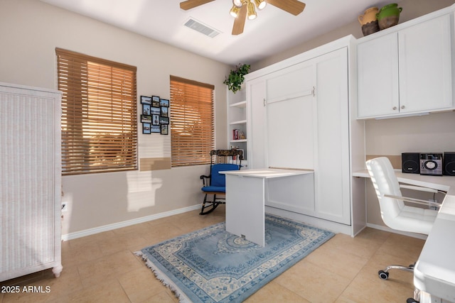 home office with light tile patterned floors, visible vents, a ceiling fan, built in study area, and baseboards