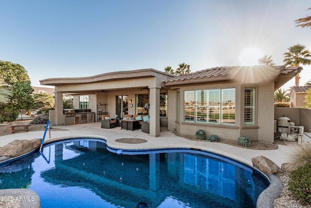 back of property with a patio, stucco siding, an outdoor kitchen, ceiling fan, and an outdoor living space