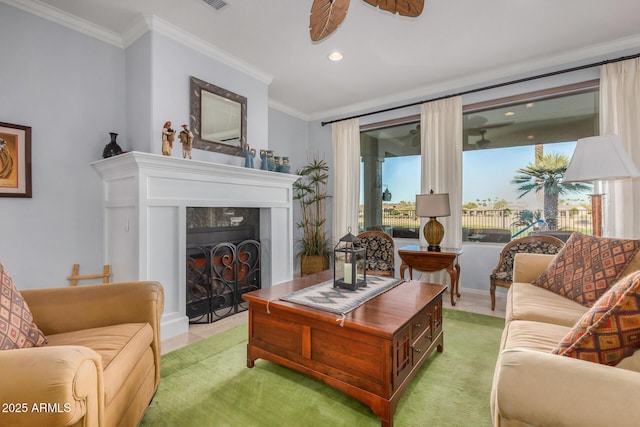 living room featuring light carpet, a ceiling fan, ornamental molding, a fireplace, and recessed lighting