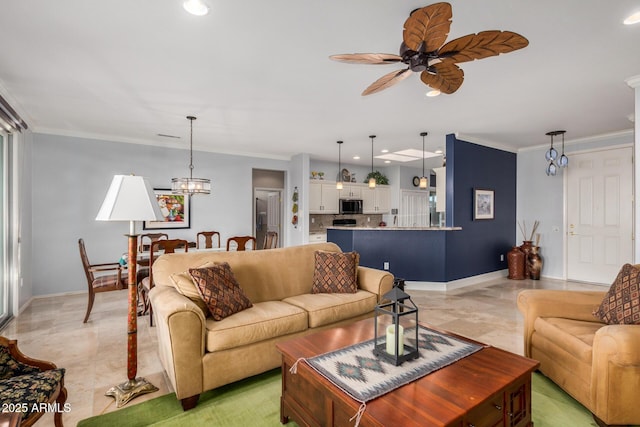 living area with ceiling fan with notable chandelier, baseboards, and crown molding