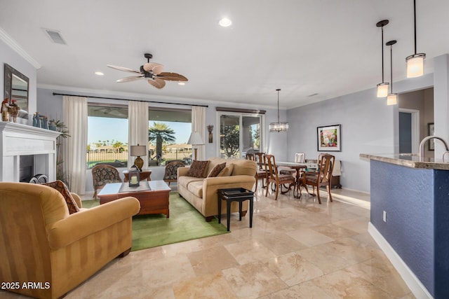 living room featuring ornamental molding, a wealth of natural light, visible vents, and baseboards