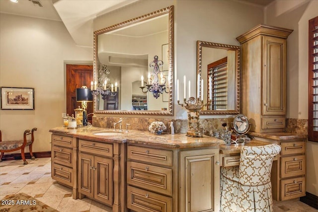 bathroom with decorative backsplash, vanity, baseboards, and a chandelier