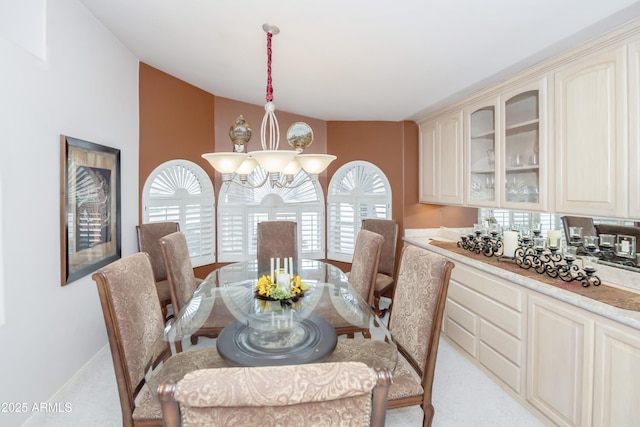 dining space featuring baseboards, vaulted ceiling, and a notable chandelier