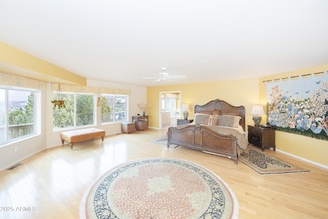 bedroom featuring light wood finished floors, baseboards, visible vents, and ceiling fan