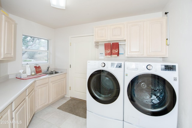 washroom with washer and dryer, cabinet space, a sink, and light tile patterned flooring