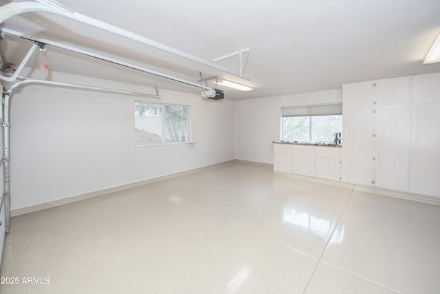 garage with a garage door opener and baseboards