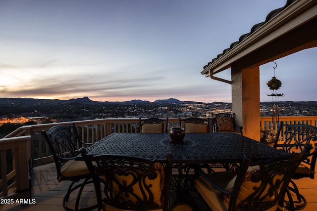 wooden terrace featuring a mountain view and outdoor dining area