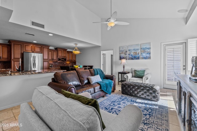 living room with ceiling fan, a towering ceiling, visible vents, and recessed lighting