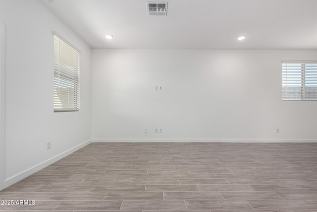 empty room with baseboards, visible vents, wood finished floors, and recessed lighting