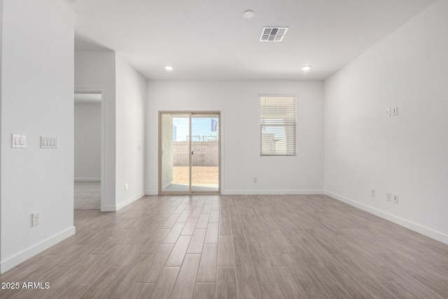 empty room with recessed lighting, visible vents, baseboards, and wood finished floors