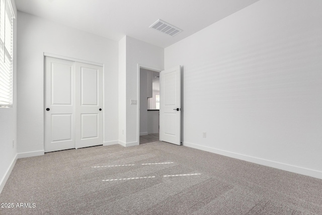 unfurnished bedroom featuring a closet, baseboards, visible vents, and carpet flooring