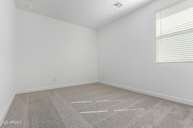 carpeted empty room featuring visible vents and baseboards