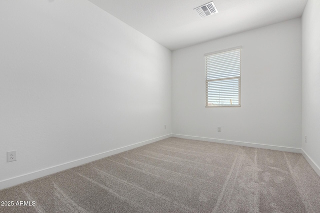 spare room featuring light carpet, visible vents, and baseboards