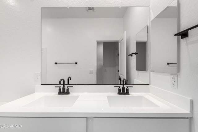 full bath featuring double vanity, a sink, and visible vents