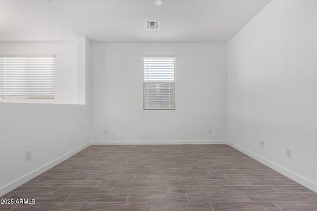 unfurnished room with baseboards, visible vents, and wood tiled floor