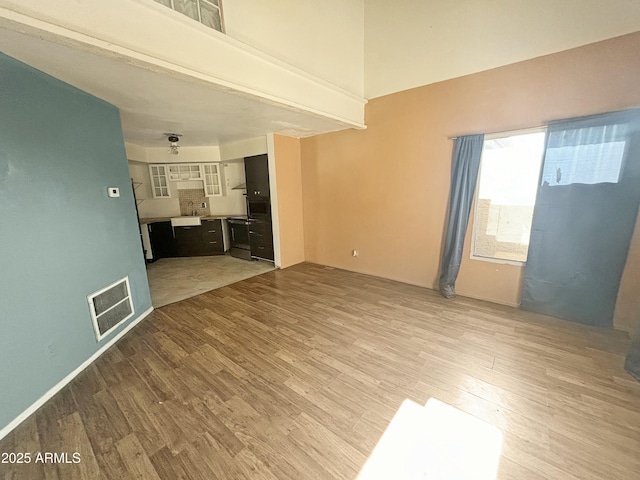 unfurnished living room featuring light hardwood / wood-style flooring and sink