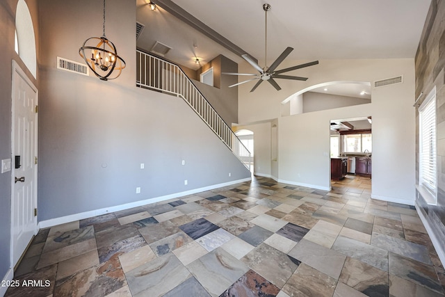 3033 E Millbrae Ln, Gilbert, AZ 85234 - unfurnished living room featuring arched walkways, high vaulted ceiling, a ceiling fan, a chandelier, and stone tile floors