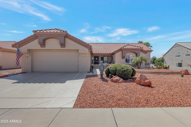 mediterranean / spanish-style home with a tile roof, concrete driveway, a garage, and stucco siding