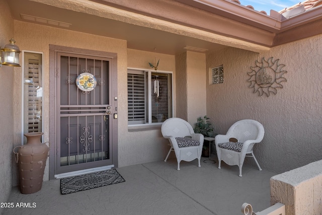 entrance to property with stucco siding and a tiled roof