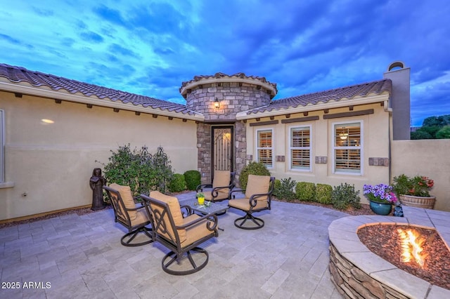 patio terrace at dusk featuring a fire pit