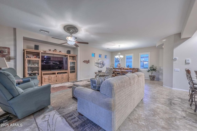 living room with ceiling fan with notable chandelier