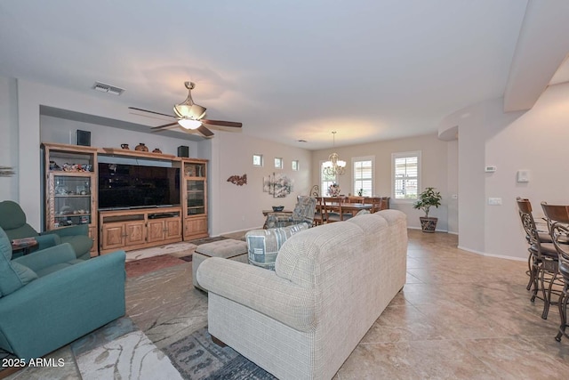 living room featuring ceiling fan with notable chandelier