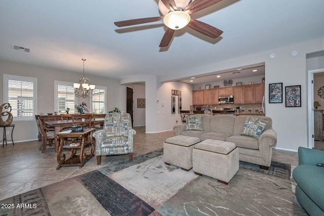 living room featuring ceiling fan with notable chandelier