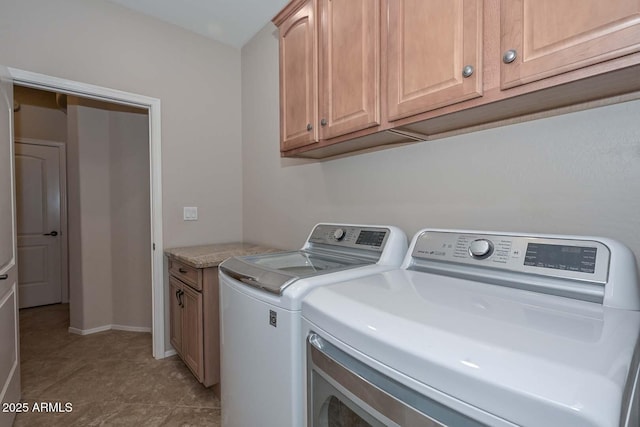 laundry area featuring separate washer and dryer and cabinets