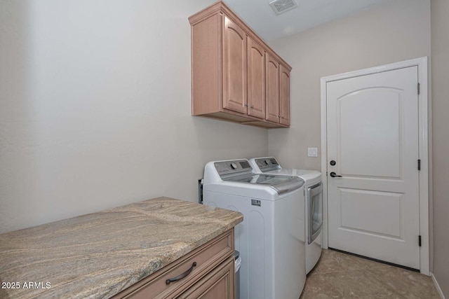 washroom featuring cabinets and washer and dryer