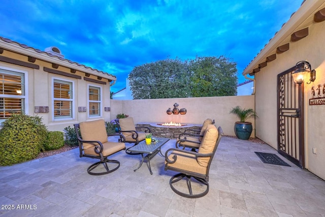 patio terrace at dusk featuring an outdoor fire pit