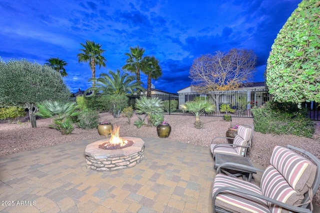 patio terrace at dusk featuring an outdoor fire pit