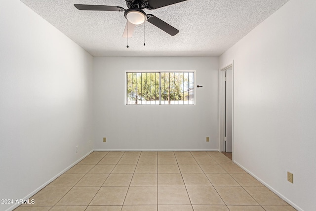 tiled spare room with a textured ceiling and ceiling fan