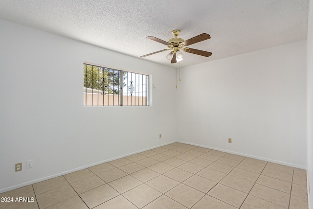 tiled spare room with ceiling fan and a textured ceiling