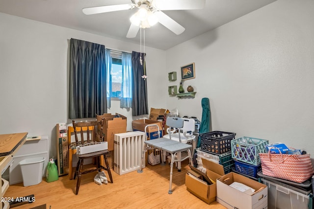 living area with hardwood / wood-style floors and ceiling fan