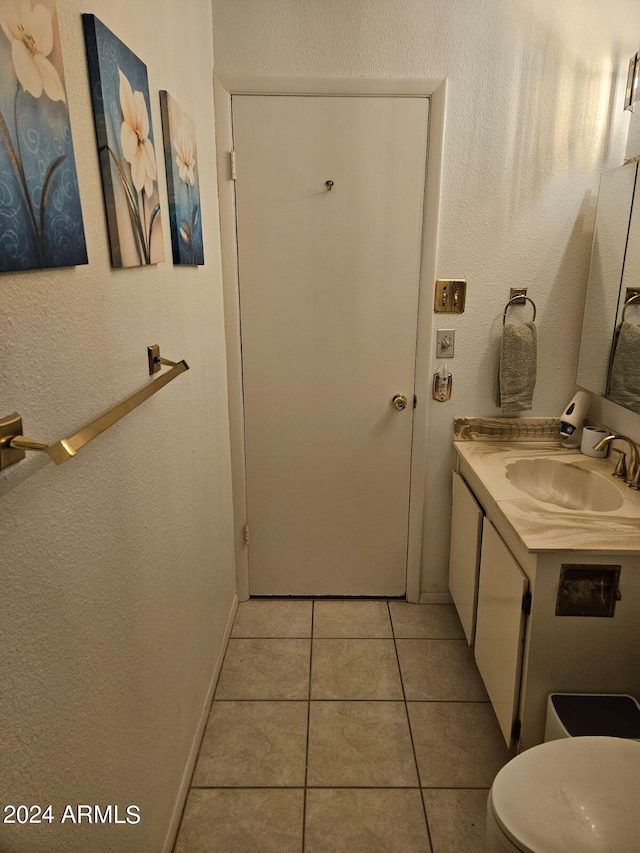 bathroom featuring tile patterned flooring, vanity, and toilet