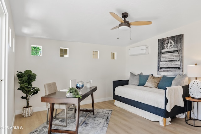 6001 N 10th Way, Phoenix, AZ 85014 - bedroom featuring a wall mounted air conditioner, light wood-type flooring, and baseboards