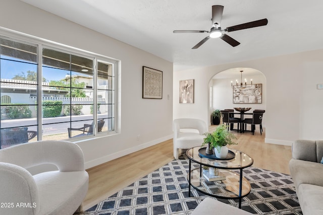 6001 N 10th Way, Phoenix, AZ 85014 - living room featuring a chandelier, arched walkways, ceiling fan, and wood finished floors