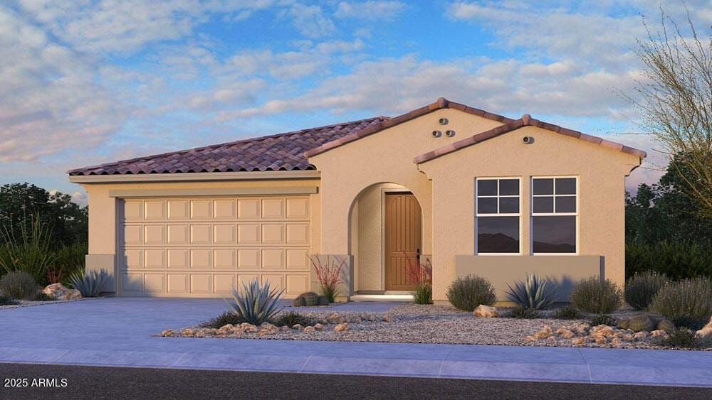 mediterranean / spanish house featuring a garage, a tile roof, driveway, and stucco siding