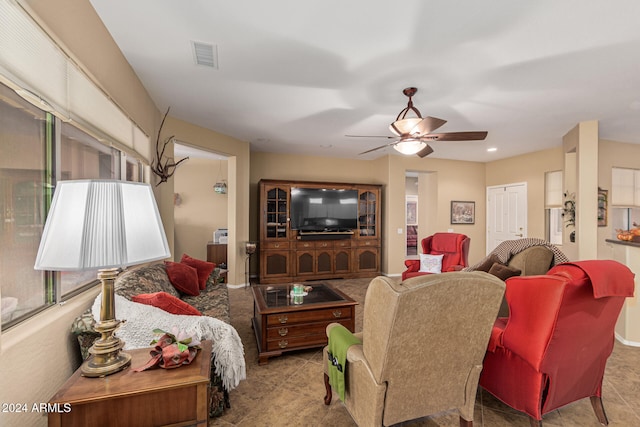 living room featuring ceiling fan and a healthy amount of sunlight