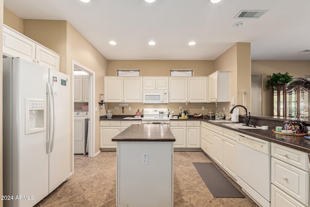 kitchen with white cabinetry, sink, kitchen peninsula, white appliances, and washer / dryer