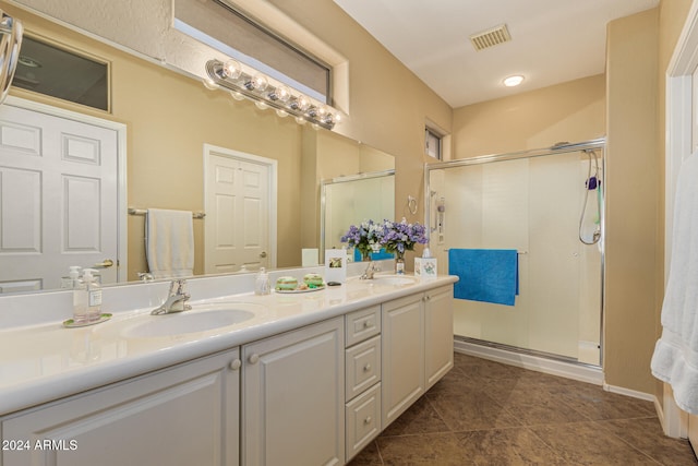 bathroom with tile patterned floors, vanity, and a shower with door