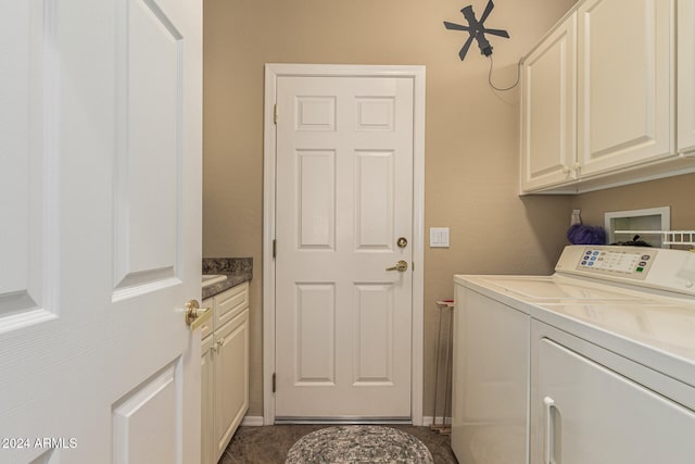 clothes washing area featuring cabinets and separate washer and dryer